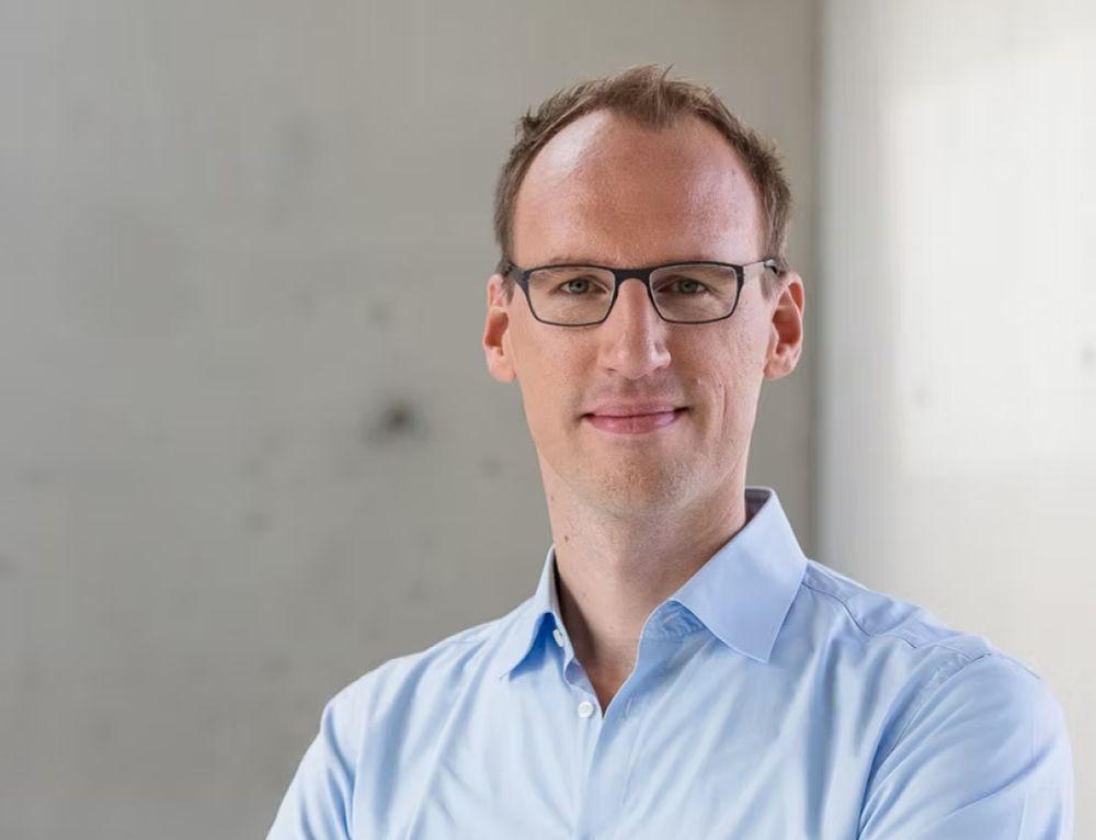 Portrait of Professor Berend Snijder with a blue button-down shirt against a blurred concrete background.