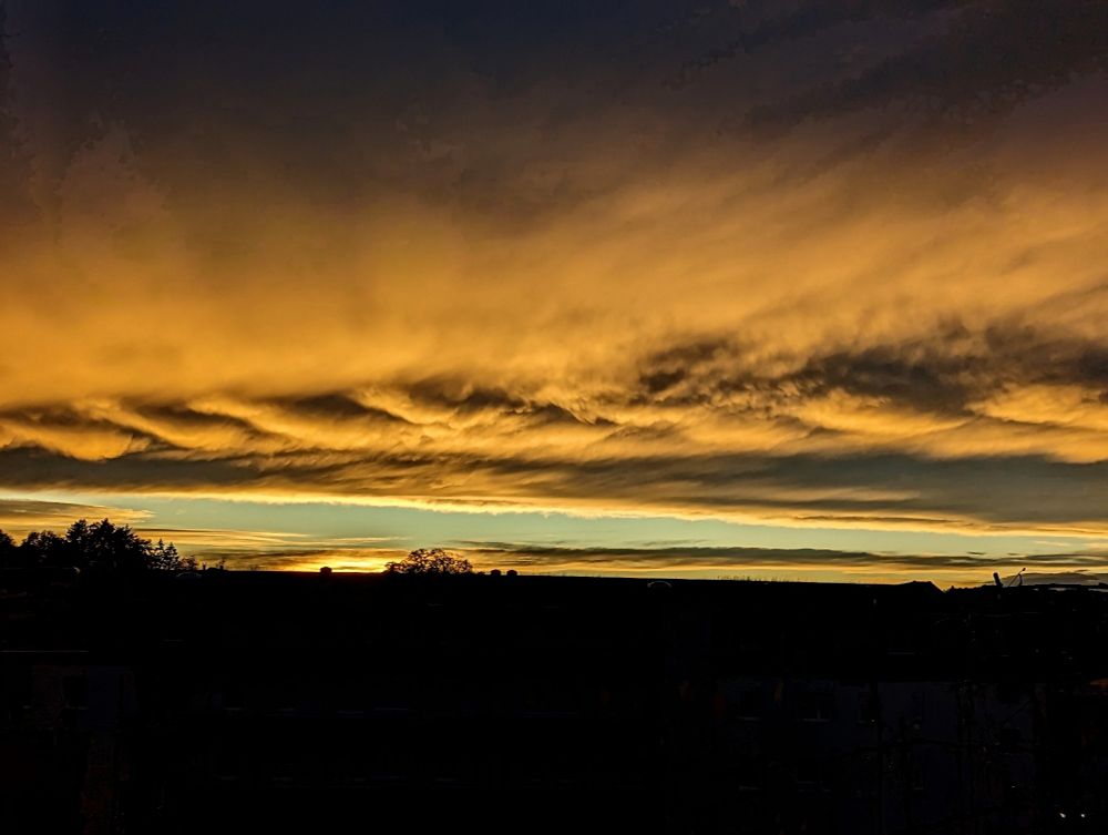 Untergehende Sonne sorgt für ein orangenes Wolkenspektakel