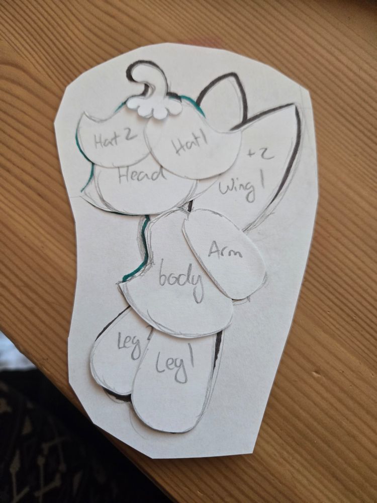 Multiple pieces of copy paper cut up and arranged on another piece of paper, resembling a fairy 