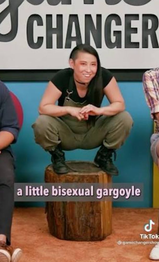Erika Ishii perched on a log like the little bisexual gargoyle that she is.