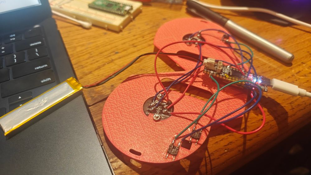 A rats nest of wires and a raspberry pi pico powering two addressable led strips. 