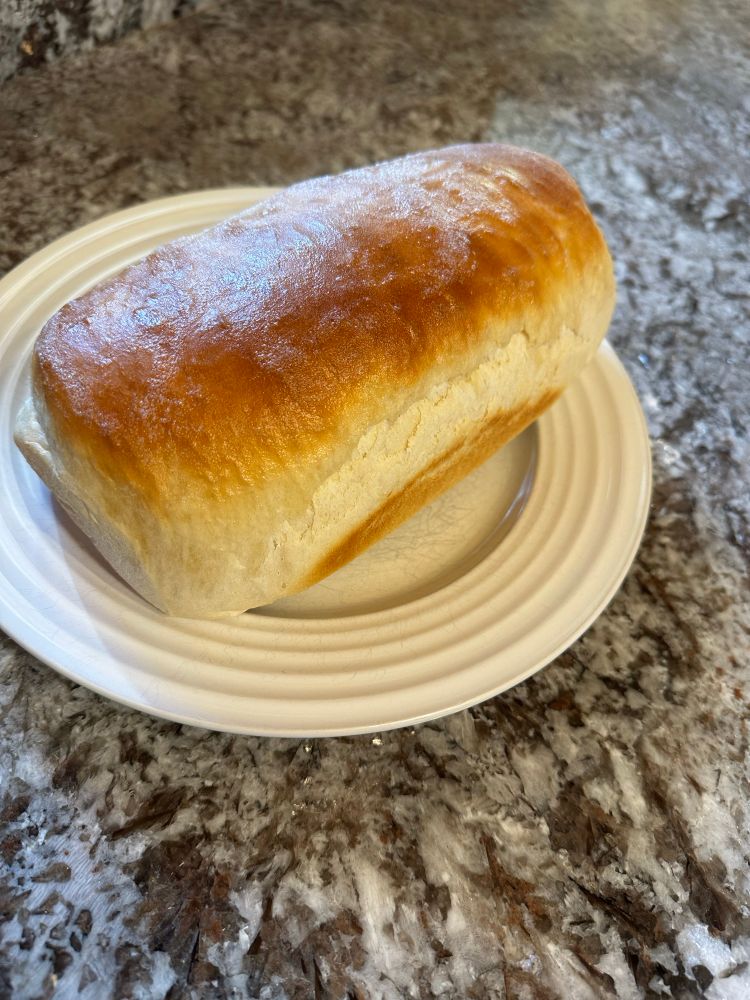 A fresh, homemade loaf of bread with golden brown crust.