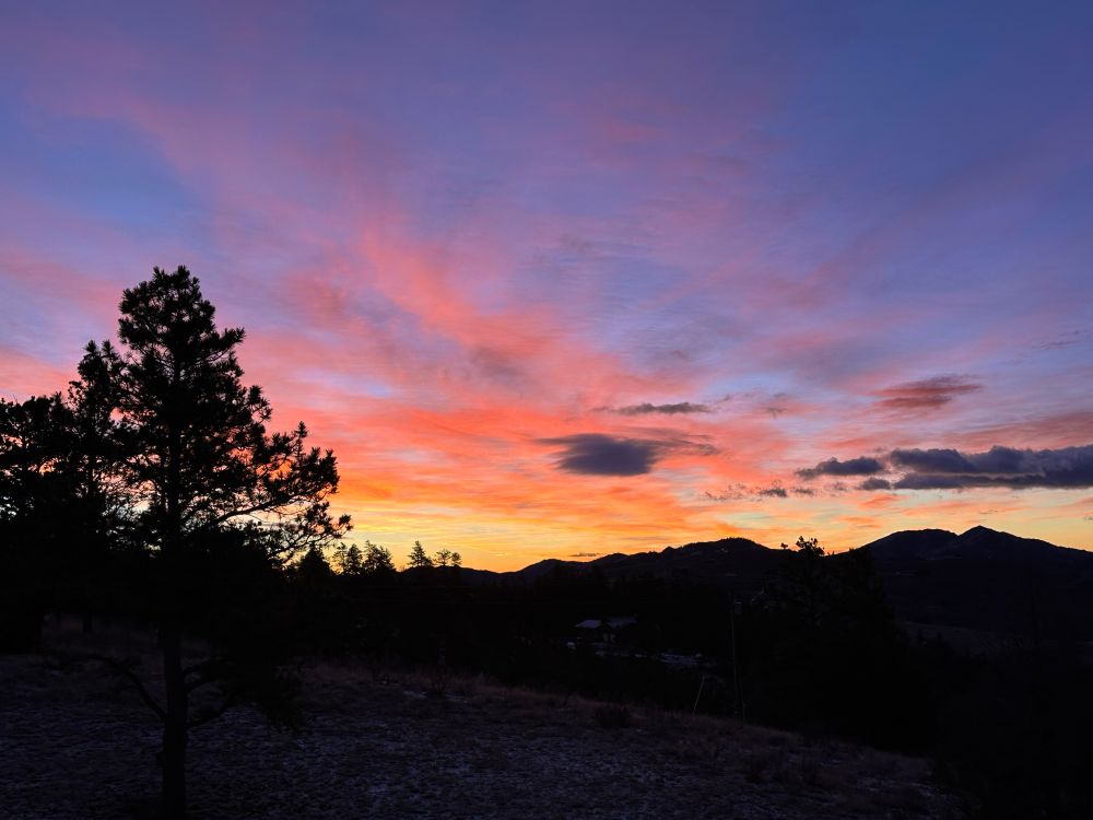 Dawn in northern Colorado with orange colored clouds over the mountains