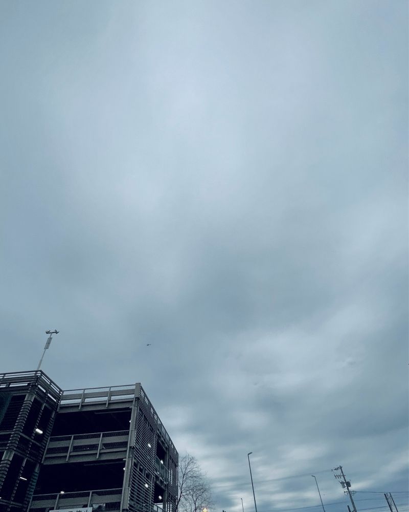 立体駐車場と曇り空の写真