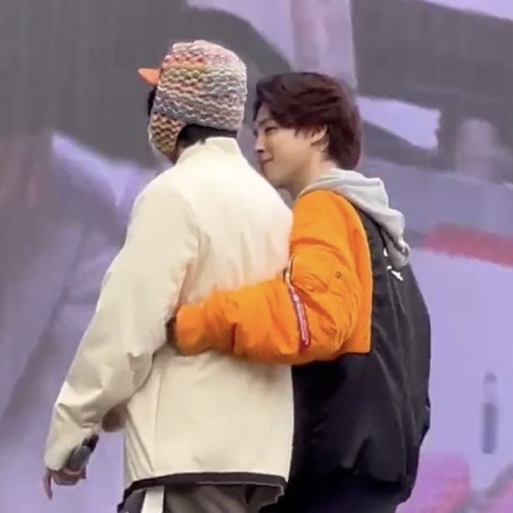 vmin walking closely together in between rehearsals, dressed in heavily padded jackets for the winter. they're walking hip to hip, with jimin's arm snugly wrapped around taehyung's face as he looks up at taehyung with a small, unwavering smile. they remain like this the entire time as they leave the stage and walk away, later arm in arm.