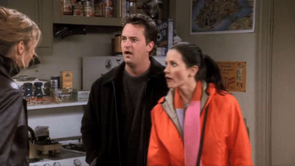 a man and two women are standing in a kitchen with a sign that says oreo