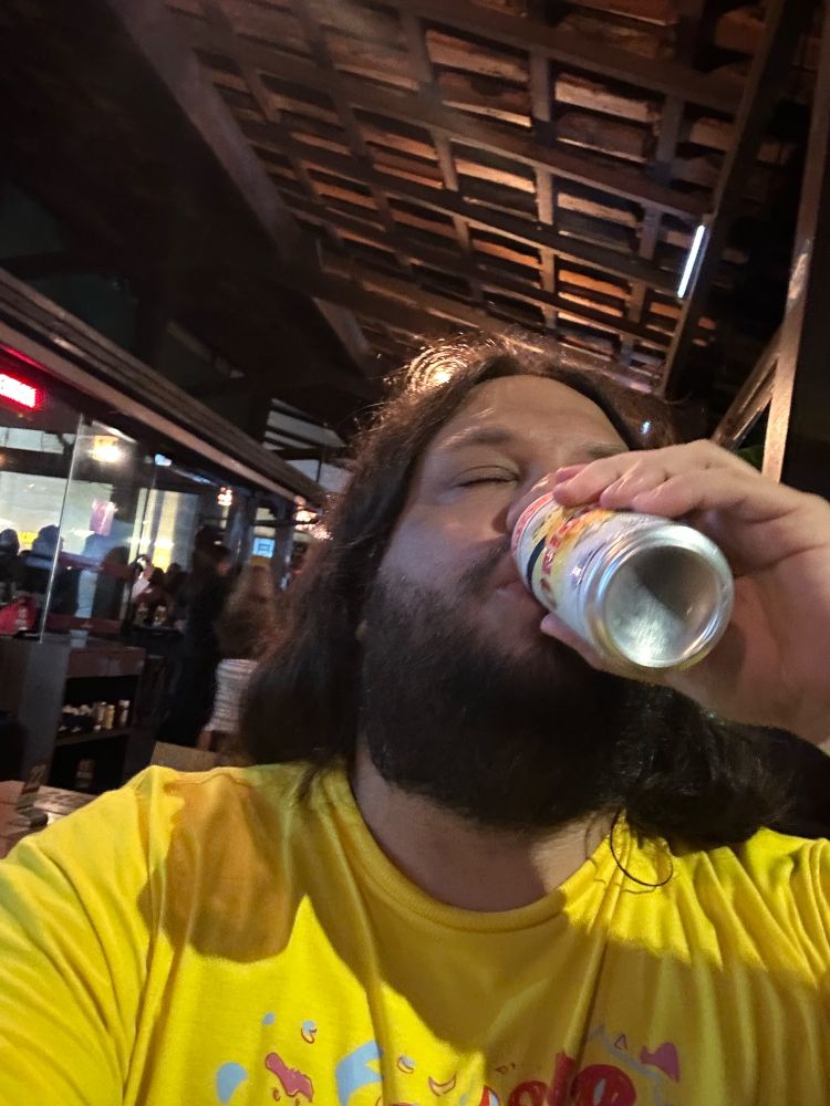 Guy on a yellow shirt chugging a beer can