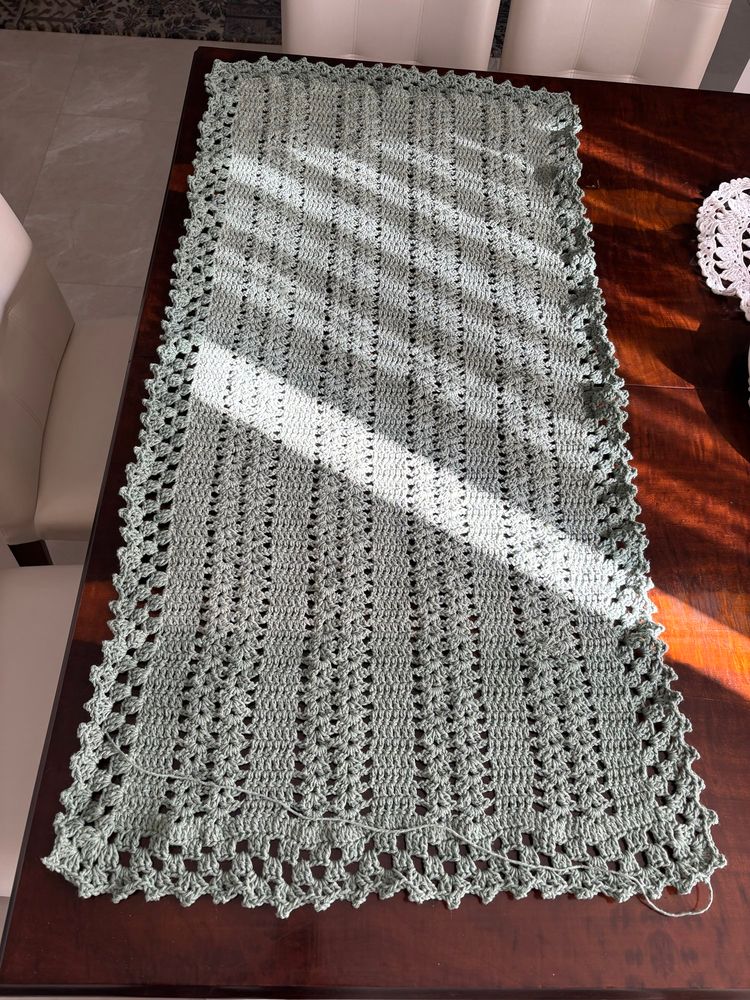 Foto de uma passadeira em crochê, na cor verde (alecrim o nome) onde se nota a diferença de tonalidade por mudança de lote/partida do novelo. Não houve a necessária conferência na hora da compra…