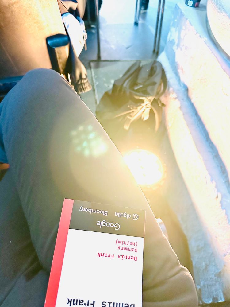 I am seated next to a very bright spotlight that shines upward from the floor. The image captures this perspective, highlighting a brilliant yellow light with prominent lens flares.