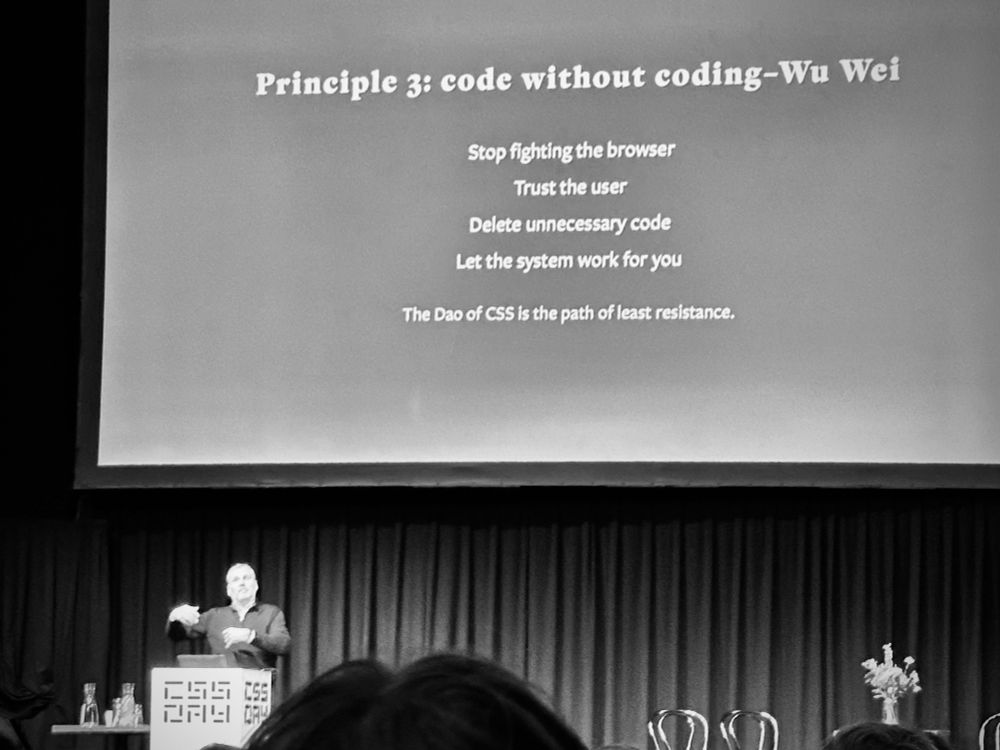 John on stage with a text-only slide: 

Principle 3: code without coding-Wu Wei

- Stop fighting the browser
- Trust the user
- Delete unnecessary code
- Let the system work for you

The Dao of CSS is the path of least resistance.