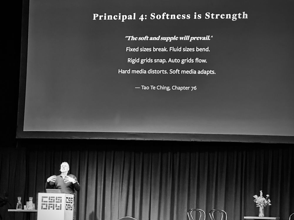 John on stage with a text-only slide: 

Principal 4: Softness is Strength

”The soft and supple will prevail.“

Fixed sizes break. Fluid sizes bend.
Rigid grids snap. Auto grids flow.
Hard media distorts. Soft media adapts.

— Tao Te Ching, Chapter 76