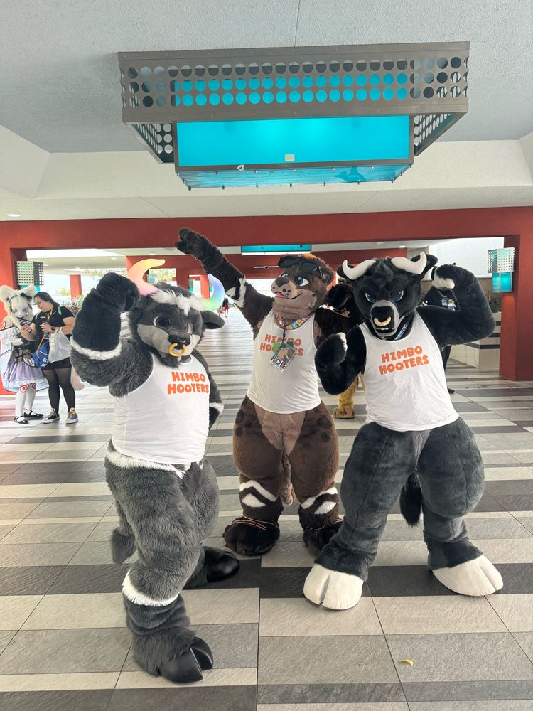 Three furries flexing! 2 grey bulls with a big otter in the center all giving flexing poses while wearing tanks that say “Himbo hooters”