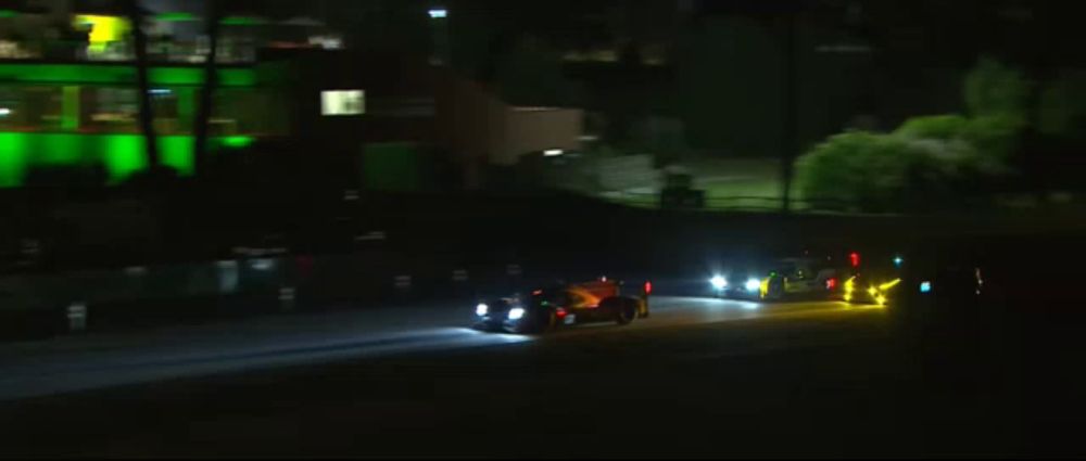 a row of cars are driving down a road at night