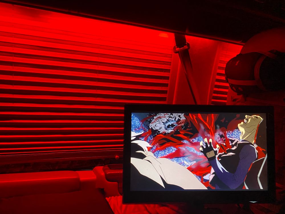 Shot of man’s chest exploding on a tv with red lights on in the background 