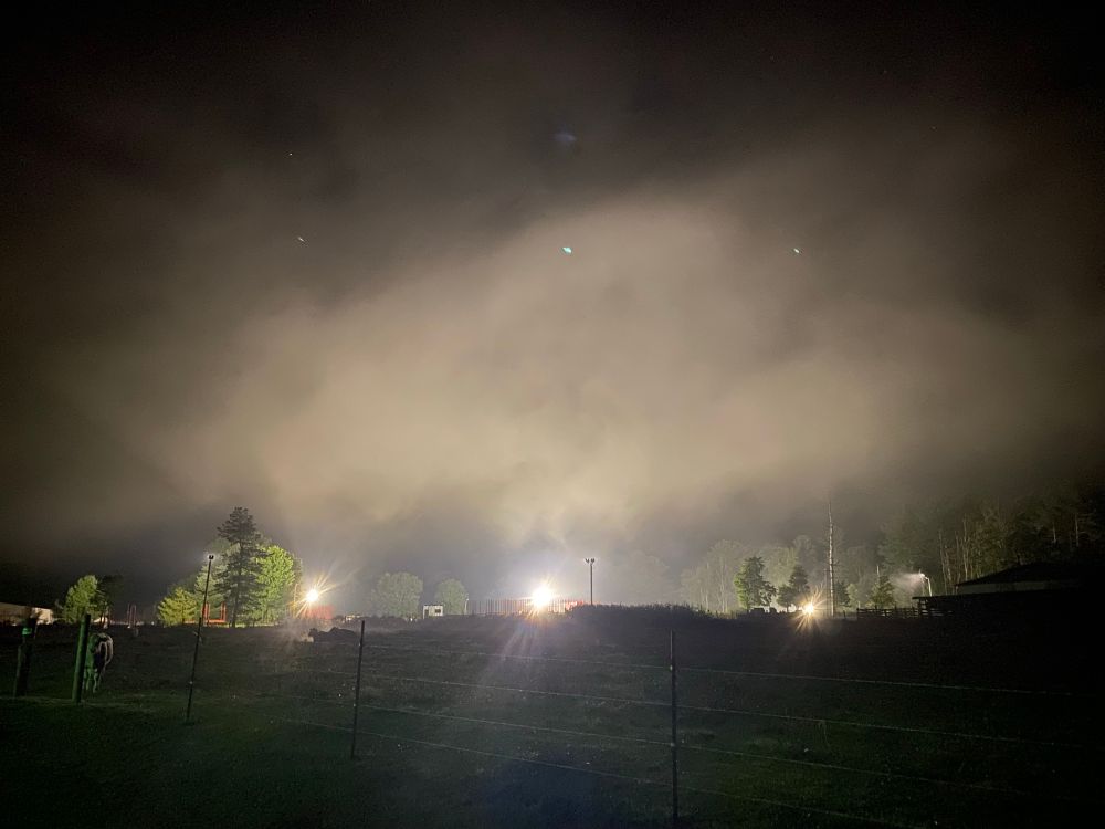 Fog descending a mountain at night and bright lights 