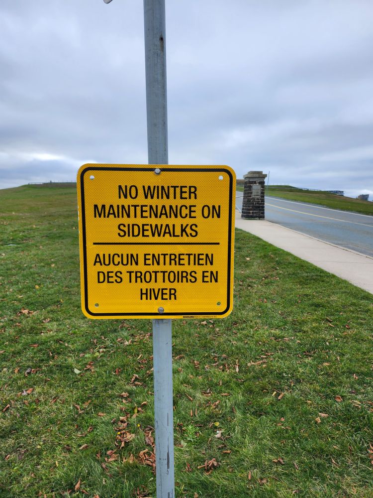 Sign stating : "no winter maintenance on sidewalks  / aucun entretien des trottoirs en hiver " on the Halifax Citadel 