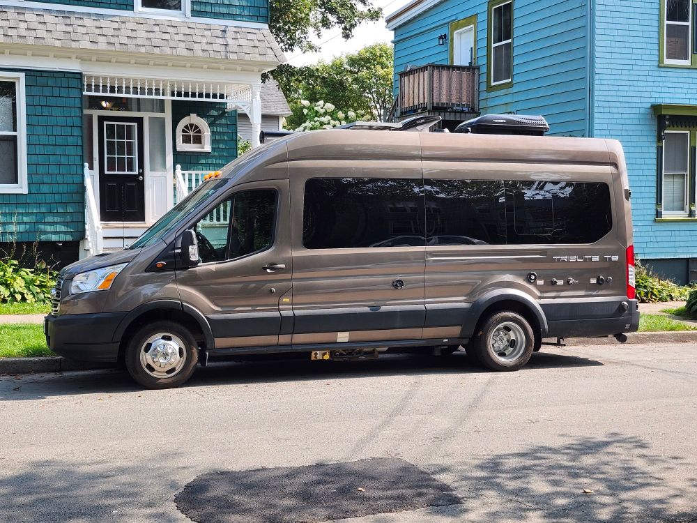 Large camper van parked on city streets.  