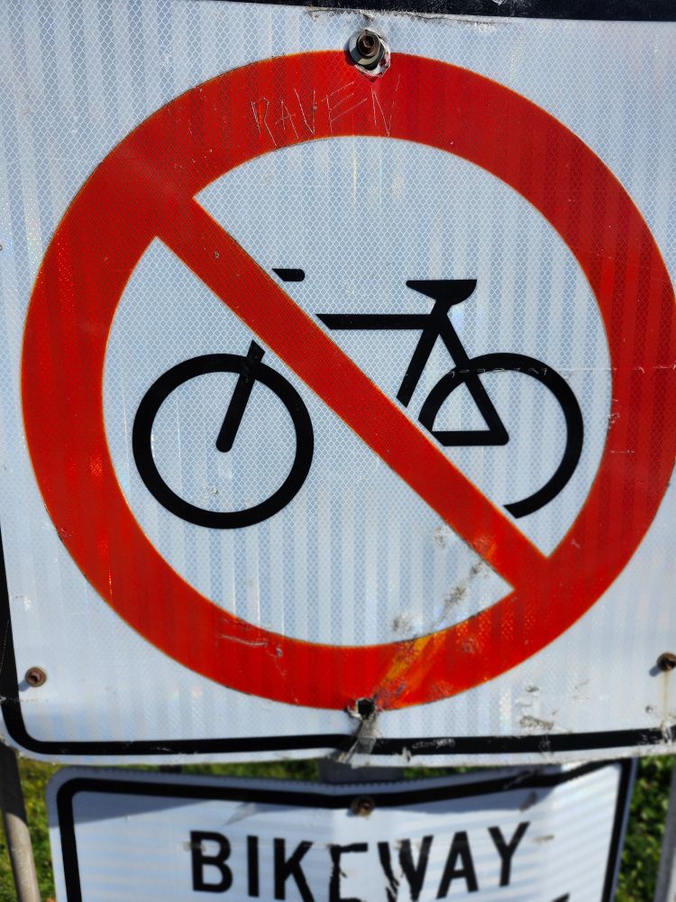 Sign with bike overlaid with red circle and diagonal line 