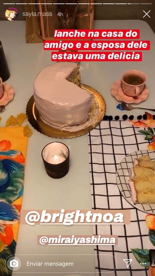 Story originalmente postado por Felipe Castanhari com o texto "lanche na casa do amigo e a esposa dele estava uma delicia", assim sem vírgula mesmo, mostrando uma mesa com toalhas estampadas, um bolo confeitado, uma xícara e uma vela acesa. A imagem foi editada para substituir o nome de usuário e a foto de Castanhari por Sayla Mass de Mobile Suit Gundam, assim como as outras contas marcadas na postagem (agora Bright Noa e Mirai Yashima).
