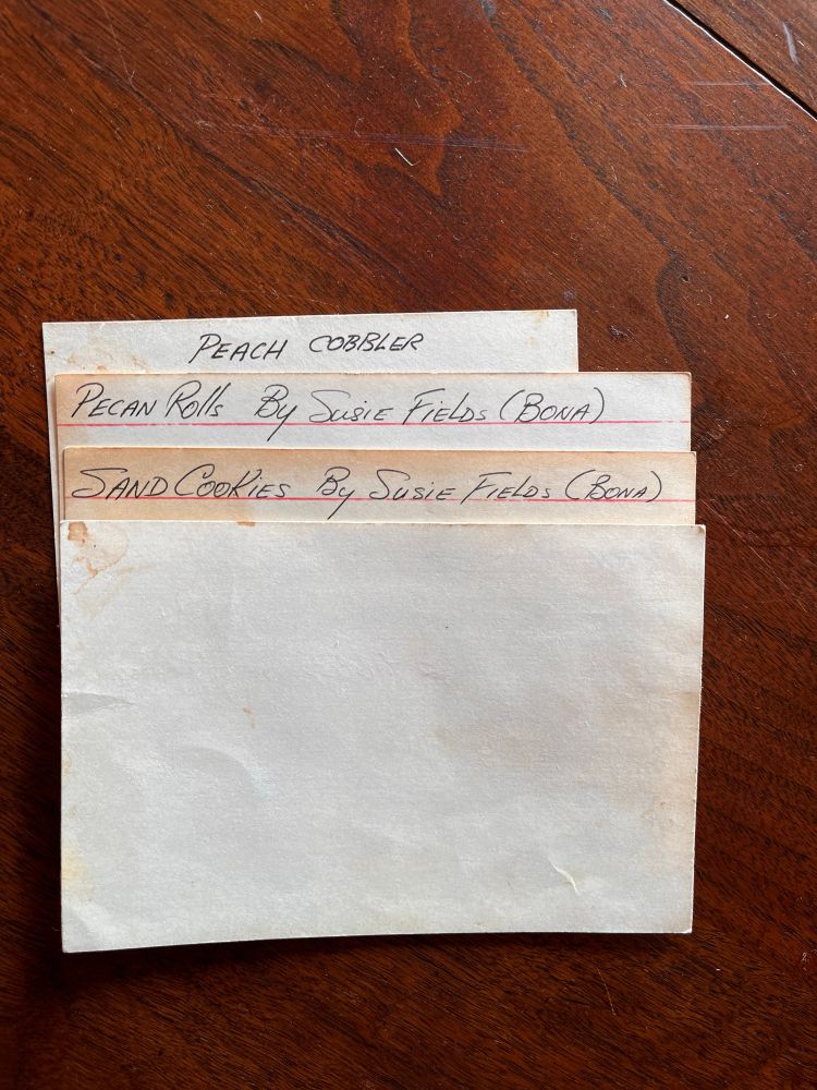 Recipe cards that read: Peach Cobbler, Pecan Rolls by Susie Fields (Bona), and Sand Cookies by Susie Fields (Bona). 
