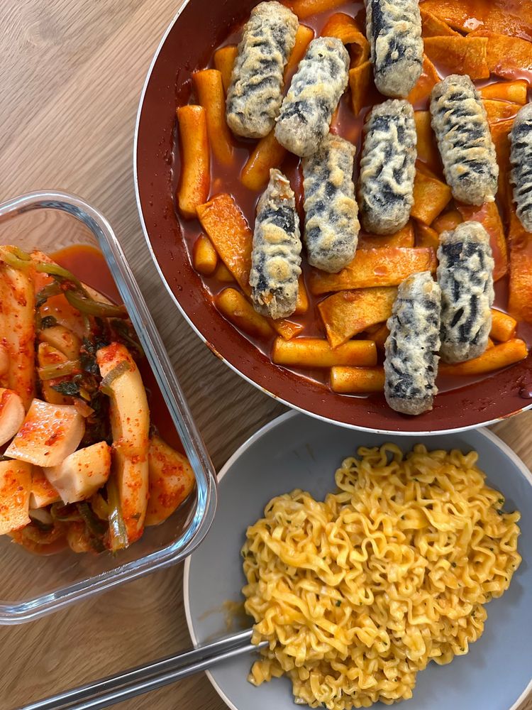 Spicy rice cakes with crispy seaweed noodle rolls, cream carbonara fire chicken noodles, and kimchi