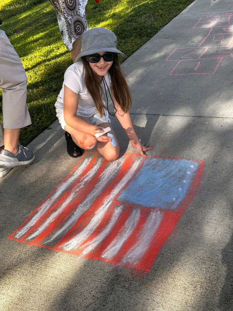 Child drawing American flag on the sidewalk in Sarasota