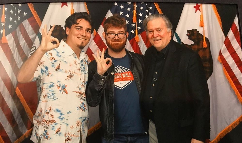 Palmer Luckey and Chuck Johnson giving the 2015 "OK" alongside Steve Bannon.