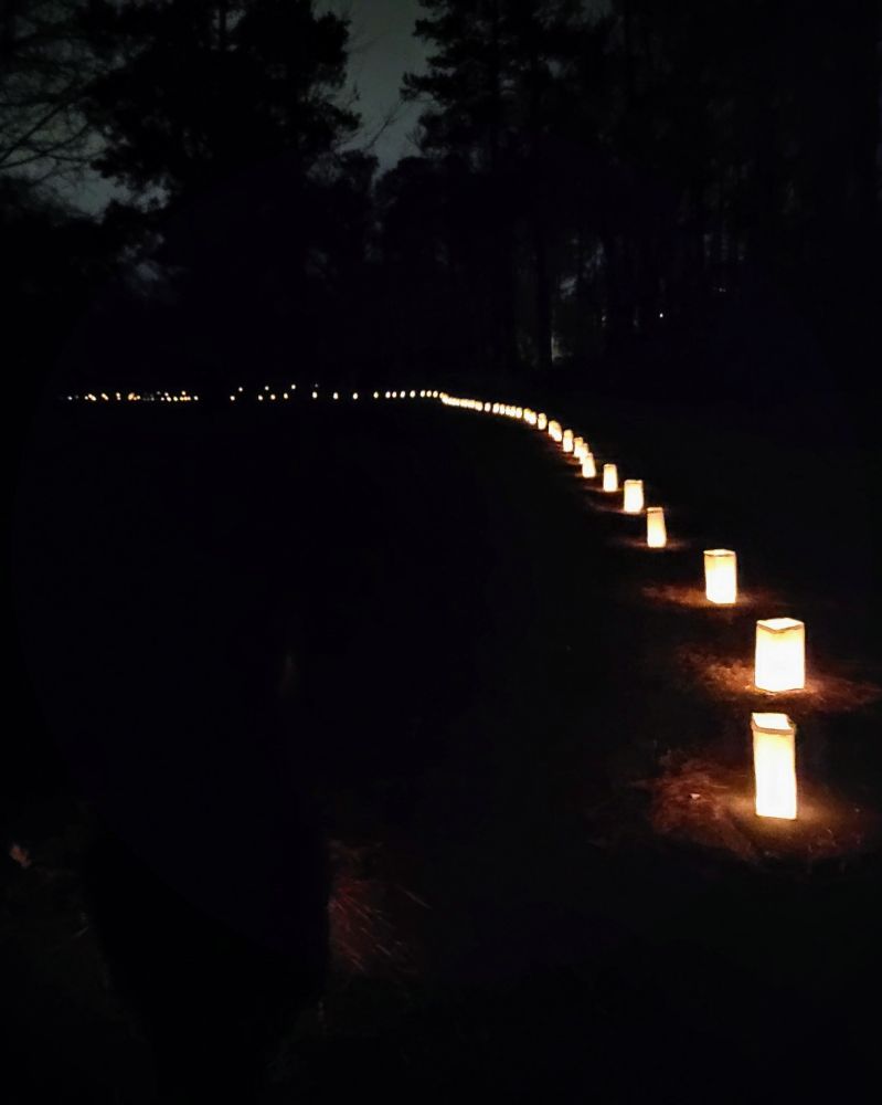 Luminaries lighted along park walkpath at night