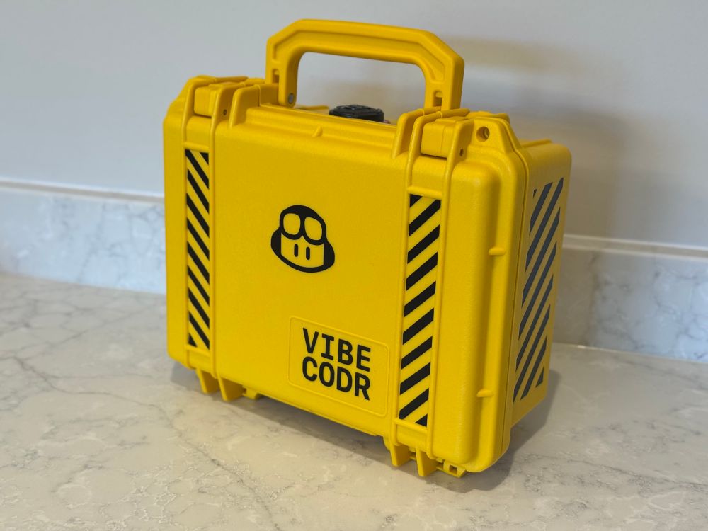 Ruggedized yellow flight case with VIBECODR written on it.