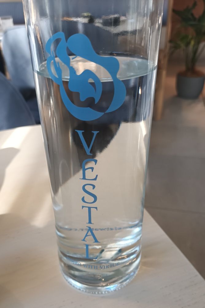 A bottle of tap water, from Vestal brand. The tag line is "water with virtue".
