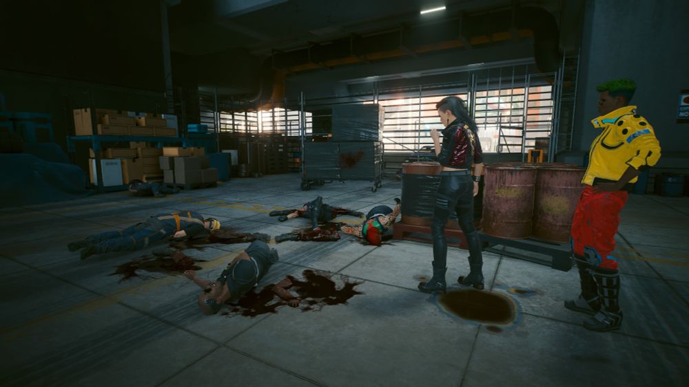 Rogue holds a smouldering cigarette as she looks at the scene of a bloody massacre. Several bodies lie on the ground. Some with severed limbs. There several blood pools on the floor. V stands behind Rogue looking at the carnage. 