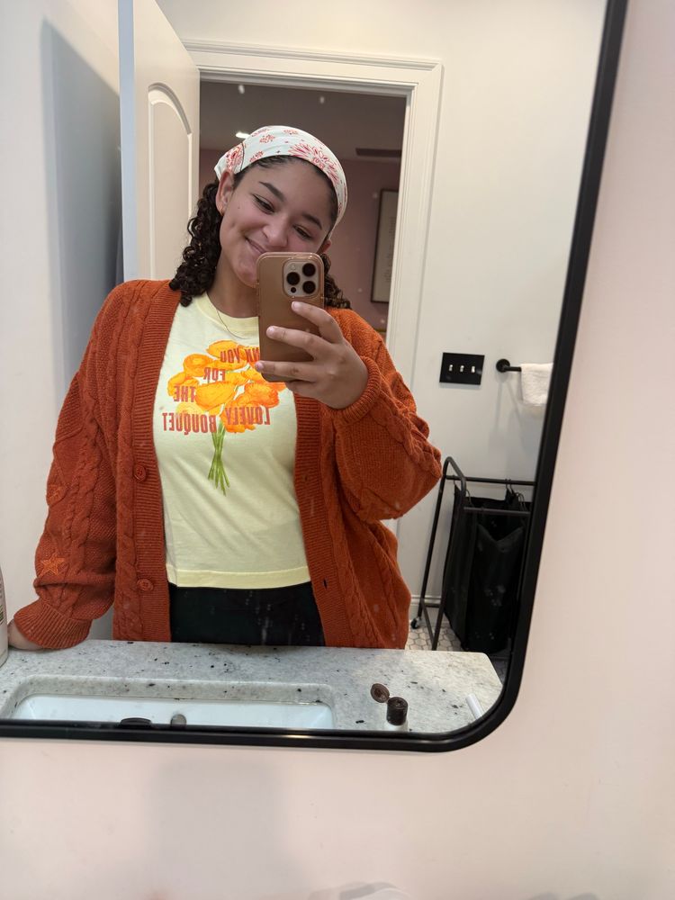 Liv wearing her showgirl orange cardigan and the thank you for the lovely bouquet yellow cropped tee.