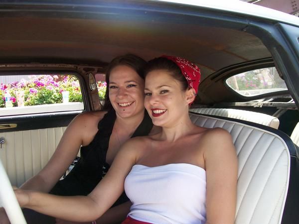 Two of my nieces in a fancy car. They are smiling and clearly love each other very much.  They are absolute sweethearts.