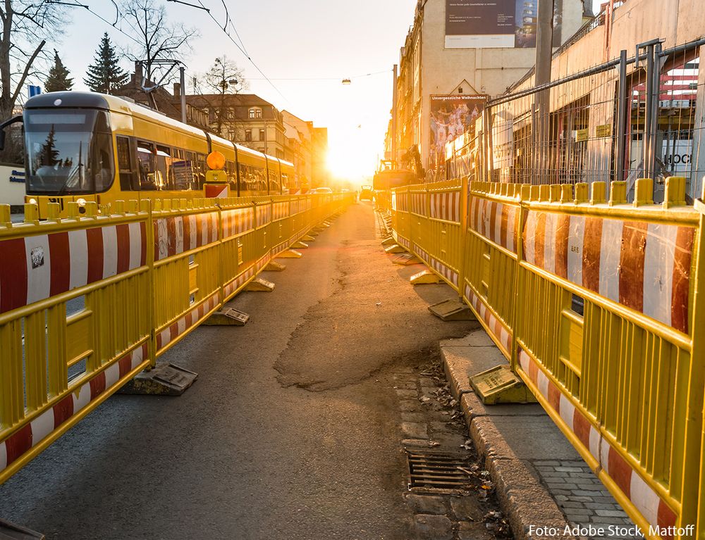 Baustelle auf einer Straße mit vorbeifahrender Straßenbahn. Foto: Adobe Stock, Mattoff.