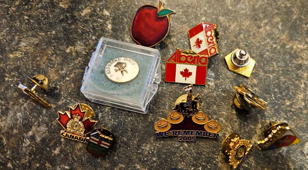Pin lot including Alberta Canada pins.