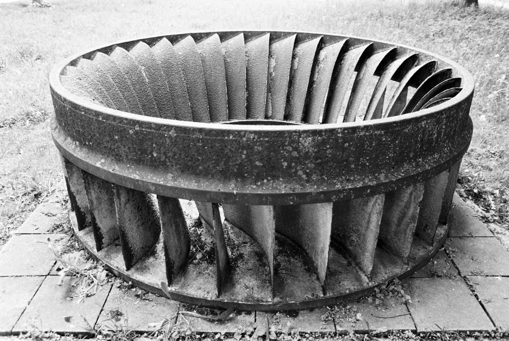 Schwarz-weiß Aufnahme eines alten Turbinenrads aus einem Wasserkraftwerk.