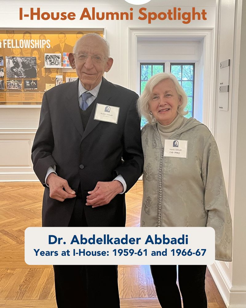 Dr. Abdelkader Abbadie featured in an I-House Alumni Spotlight, standing next to another alum in a gallery adorned with framed pictures and informational displays. Both are wearing name tags and smiling.