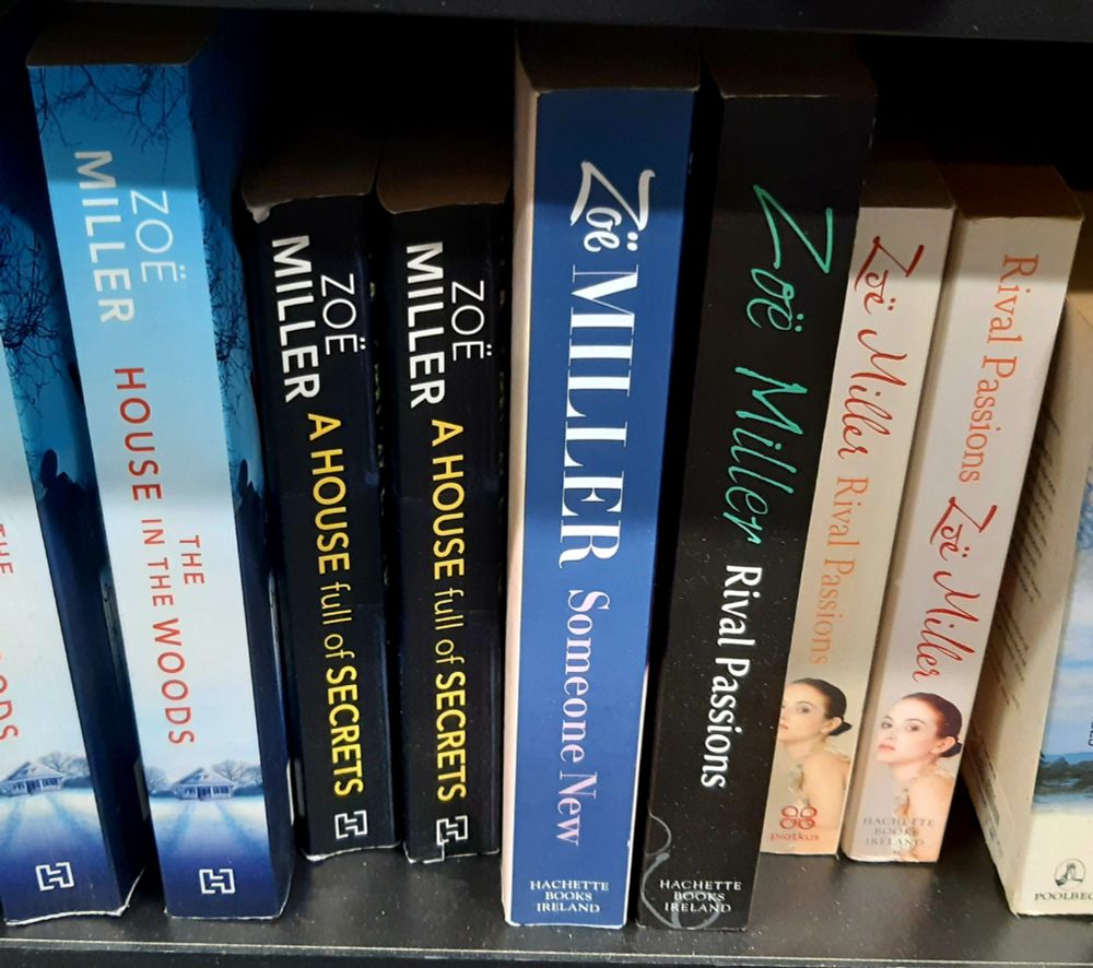 Picture shows books on a shelf including Rival Passions, Someone New, A House full of Secrets and The House in the Woods 