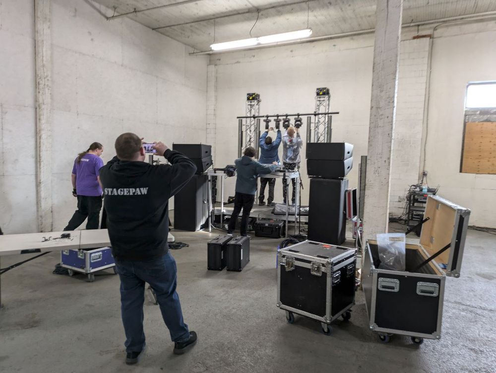 A photo of a group of people setting up A/V equipment for the party.