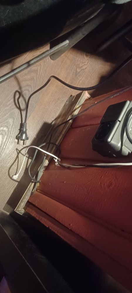 A photo of an electrical plug not connected to the outlet