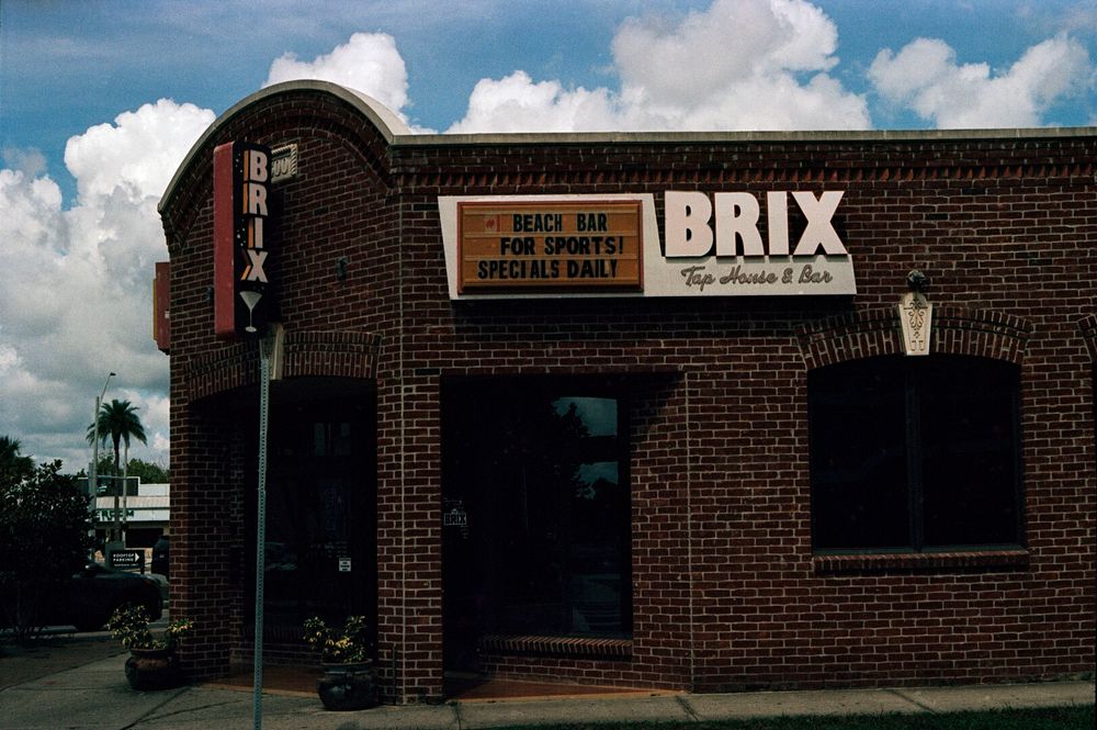 A one story brick building with a sign on it that says “BRIX Tap House & Bar”. There is also a changeable bit to the sign that says “#1 Beach Bar For Sports! Specials Daily.