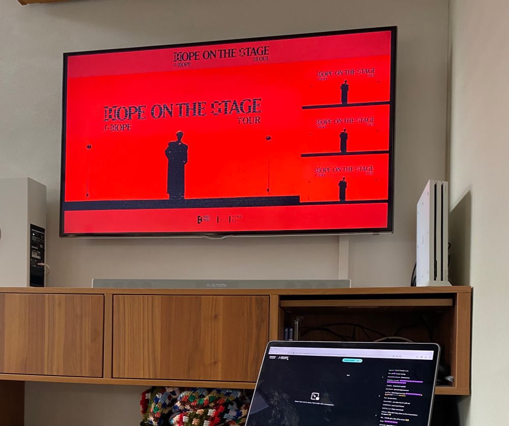 Set up for jhope concert Stream in multiview, the tv shows the split screen Multi view concert Titel from hope on stage, Sound System and MacBook with chat 