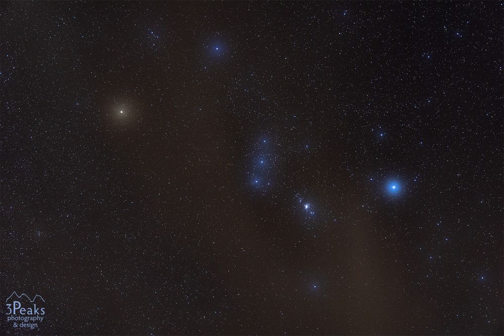 Orion behind a thin cloud cover.