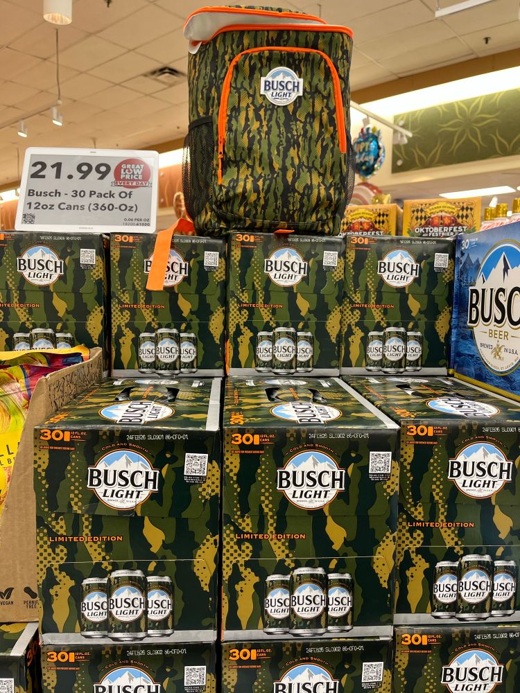 A grocery store display featuring cases of Busch Light beer in seasonal camouflage cans.
