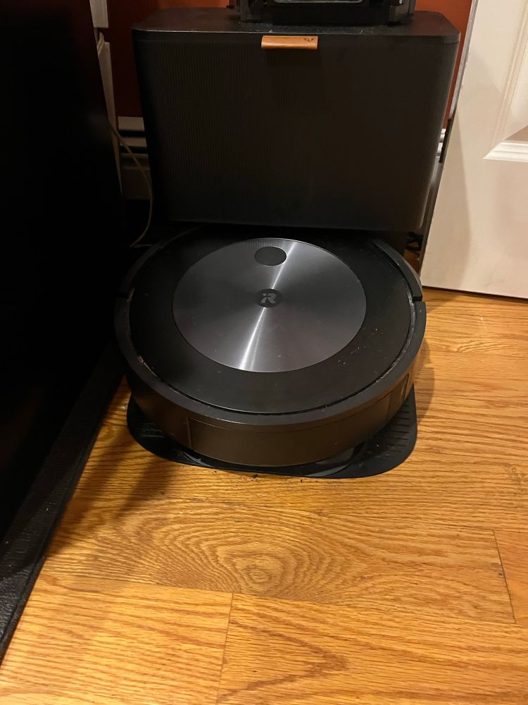 A Roomba vacuum cleaner in its docking station.