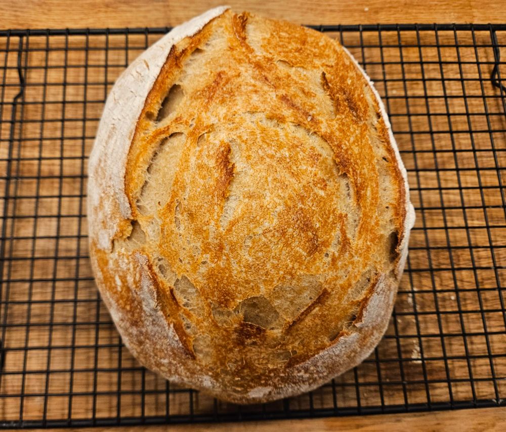 Miche de pain dorée refroidissant sur une grille