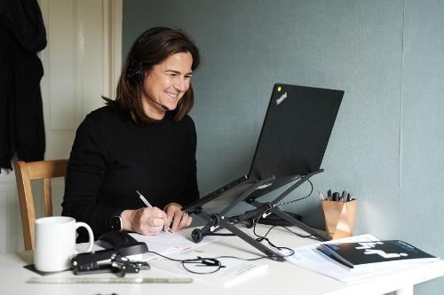Nurse smiling while having an online meeting with a patient. 
