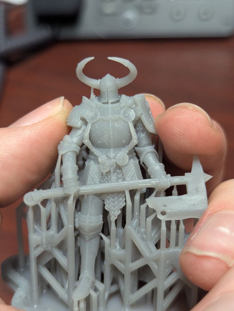 A Hand holding a resin printed miniature, a hell knight from trench crusade.