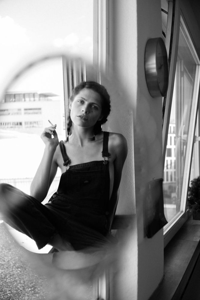Model im Spiegel mit Zigarette in der Hand. Schwarz weiß 