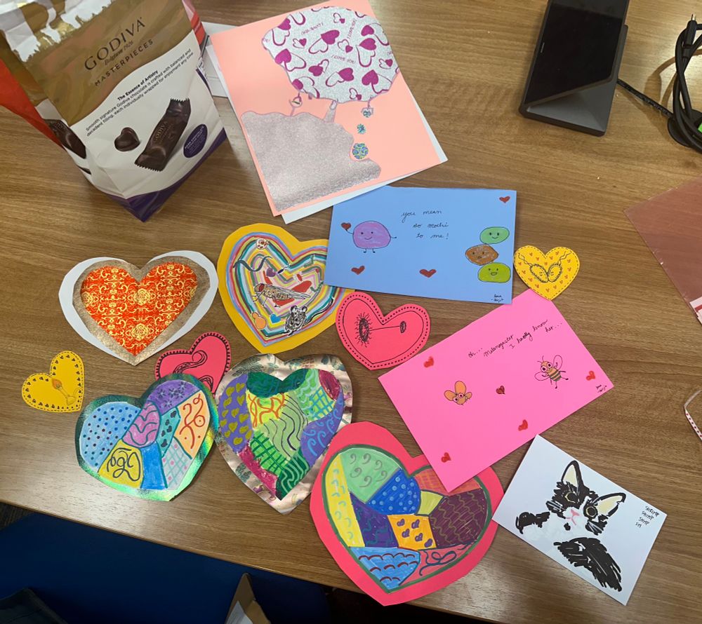 A collection of heart shaped and rectangular decorated cards with colorful patterns and drawings many science-themed. 